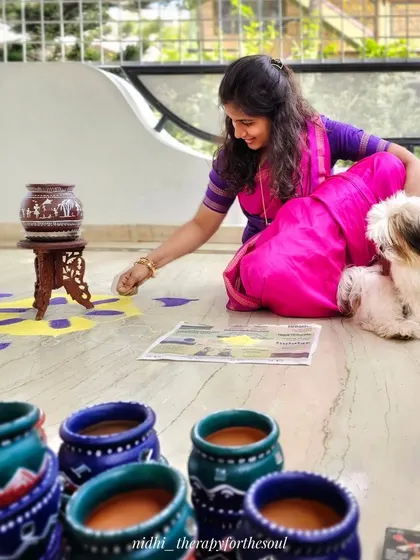 Getting ready for the Sankranti festival. Here I am, with my furry assistant, attempting to create a rangoli. It's not my strongest skill, but it's always fun to try.