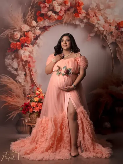 A portrait of a queen. The tiara and the stunning peach gown make this mama-to-be look absolutely regal in the boho floral ring setup.