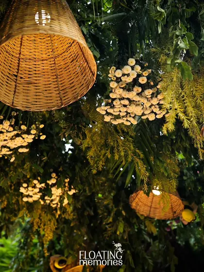 An upward view of the hanging decor, showing how we layered woven lampshades and floral clusters to create a rich, textured ceiling that defined the entire event space.