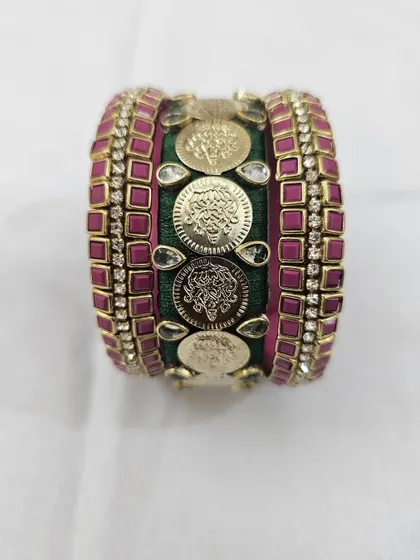 This front-on shot shows the symmetry and rich detailing of the green and pink bridal bangle set.