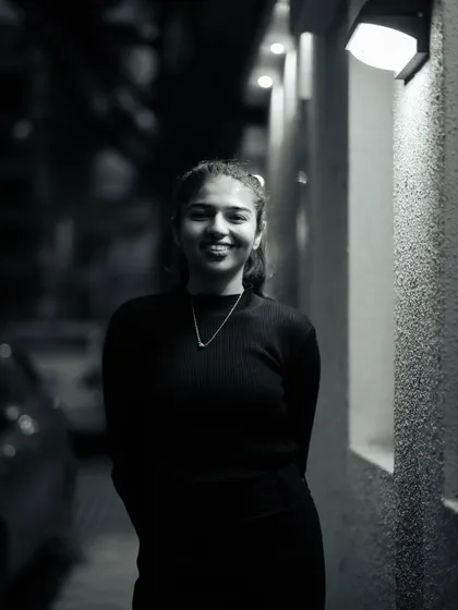 A friendly and approachable black and white portrait. The simple lighting and genuine smile make this a warm and inviting image.