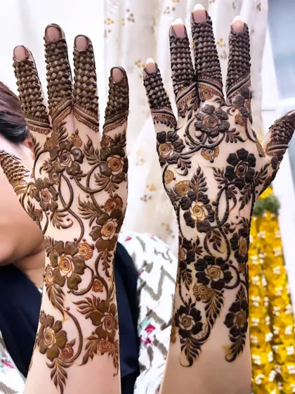 A stunning floral vine design that covers the back of the hands. The intricate latticework on the fingers is beautiful.