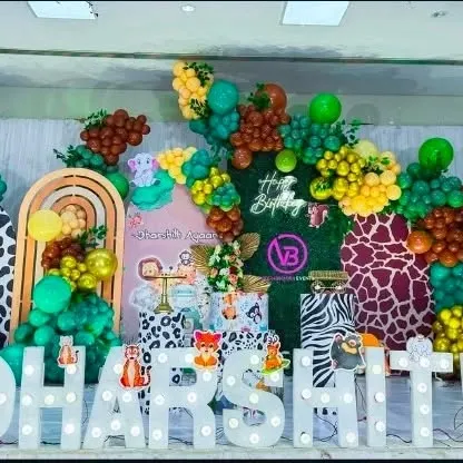 A vibrant jungle-themed birthday party. This setup uses animal print backdrops, lots of green and yellow balloons, and cute animal cutouts.