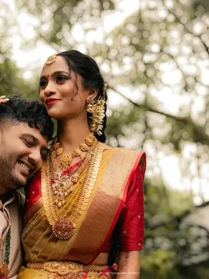 A tender moment of embrace in a beautiful garden setting. The groom's gentle affection and the bride's peaceful expression tell a story of love and comfort.