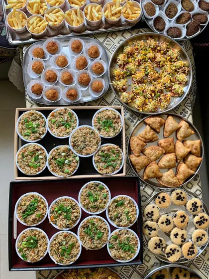 A birthday party spread with fried rice, samosas, cookies, and fries.