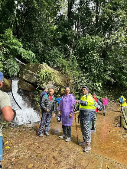 A group discussion on the trail, with a small waterfall in the background. I always ensure my group is well-informed and safe.