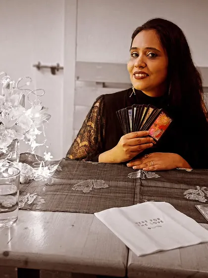 A black and white photo of me with my cards at a Bumble event. The timeless nature of tarot is reflected in this image, a practice that has guided souls for centuries.