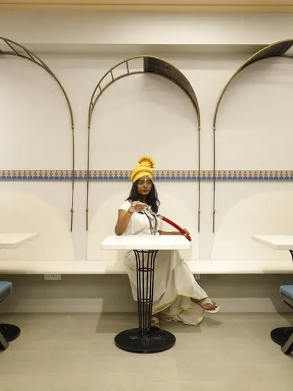 The seating area at Sangam Sweets is framed by delicate, filigree-like metal arches. This design element creates intimate nooks for customers while echoing the traditional architectural themes of the space.