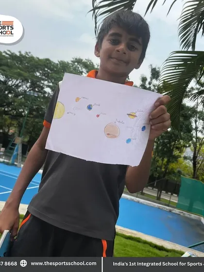 A student proudly shows his drawing of the solar system, combining art with astronomy.