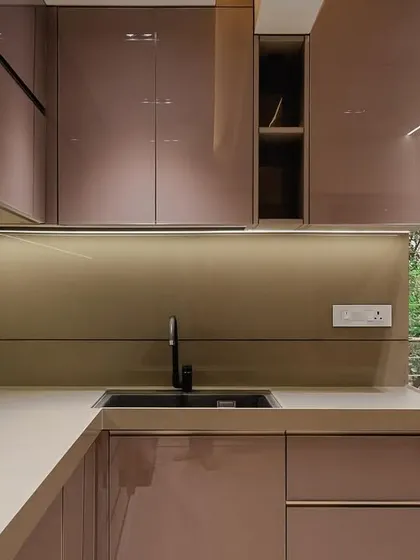 The epitome of elegance, this kitchen in Malad showcases a full back-painted glass finish in a rose gold shade, complemented by a sleek G handle and premium hardware from Hafele and Blum.