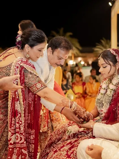 A poignant moment as parents perform a ritual during the wedding ceremony. This image captures the deep cultural significance and the emotional bonds of family in an Indian wedding.