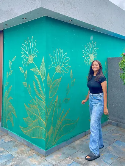 Beyond mandalas, I love creating nature inspired murals. This piece features delicate floral line art in metallic gold against a rich emerald green wall, adding a touch of elegance to an outdoor space.