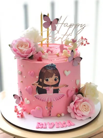 A pretty pink cake for a little ballerina, decorated with hearts, flowers, and edible butterflies.