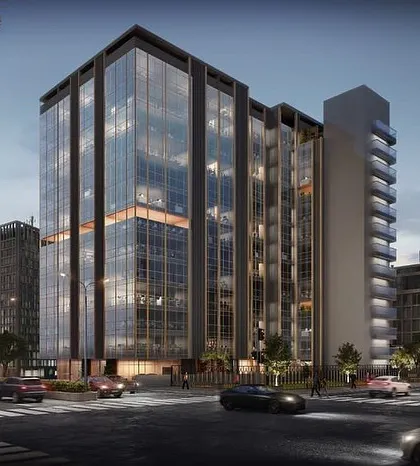 A night view of the same commercial office building. This rendering highlights the structure's appearance after dark, showing how the interior lighting transforms it into a beacon in the city.