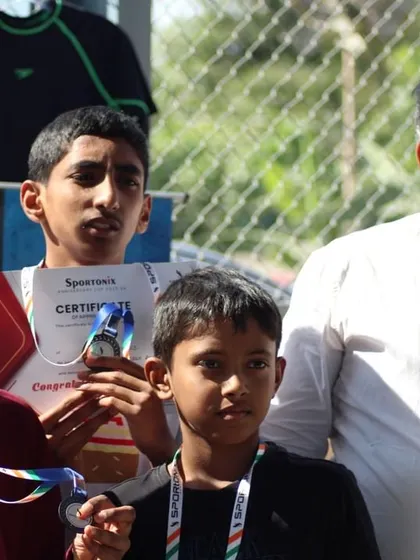 A young winner receives his medal, a proud moment for the athlete and his family.