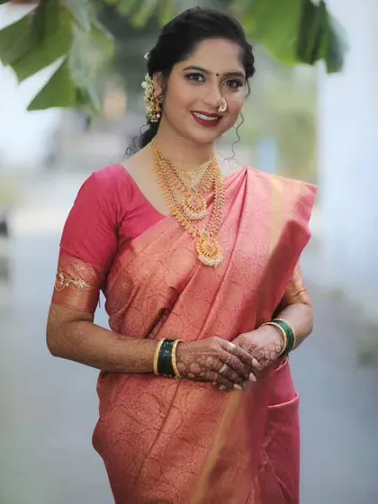 A smiling portrait of the bride, showcasing her complete look, from the makeup to the perfectly draped saree.