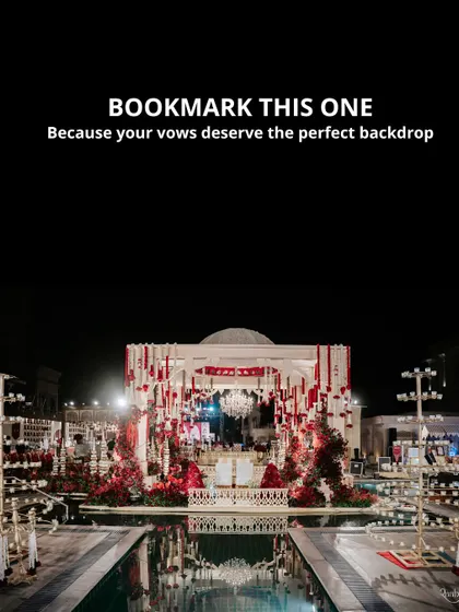 We transform magnificent venues into sacred spaces for your vows. This poolside mandap, set against the night sky with dramatic red florals and a cascading crystal chandelier, reflects our passion for creating opulent and deeply romantic wedding ceremony backdrops.