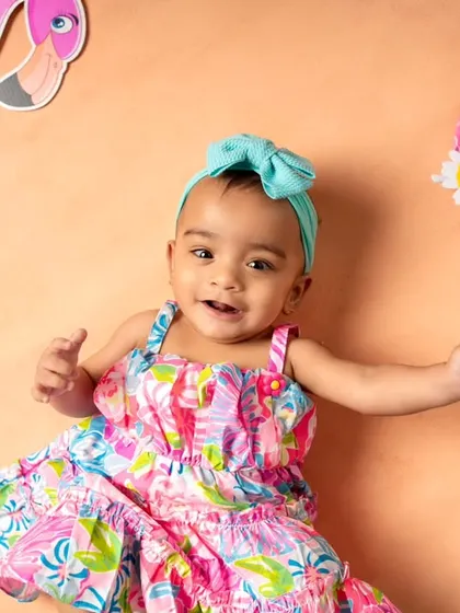 Getting into the summer spirit with a vibrant flamingo and beach theme! This little girl looks adorable in her colorful dress and matching headband.
