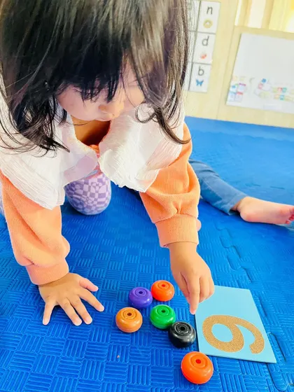 Another child practices counting with colorful rings, an engaging activity that makes learning math fun.