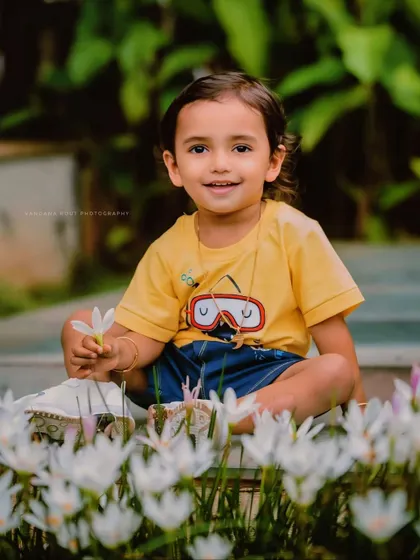 This toddler is enjoying a moment among the flowers. His bright yellow shirt and happy smile bring so much life to this natural, outdoor portrait.
