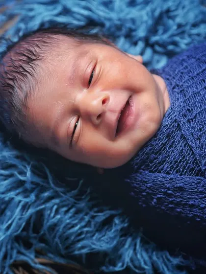 A heart-melting smile from a sleeping baby swaddled in blue. These are the magical, fleeting moments I am always ready to capture.