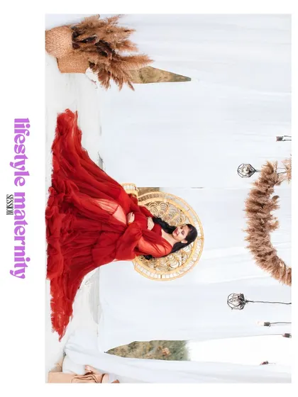 An artistic, rotated image labeled "lifestyle maternity session," showing a woman in a red gown in a stylishly decorated studio.