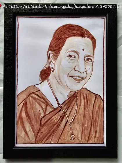 A beautifully detailed blood portrait of an elderly woman, likely a mother or grandmother. The artwork captures her warm smile and is set in a simple, elegant black frame.