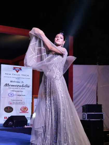 A model showcases a glittering silver gown with dramatic sleeves on the Memorabilia runway.