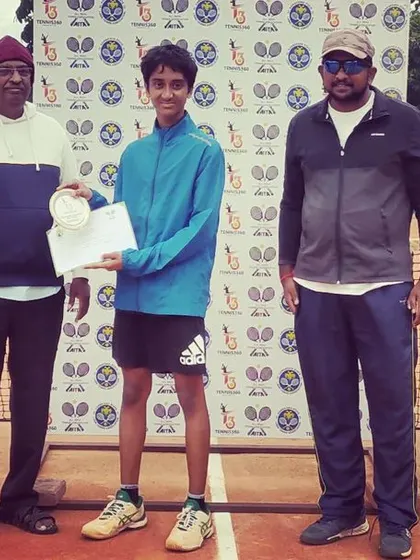 A junior player is awarded his medal and certificate for his performance in the AITA TS7 U-14 tournament.
