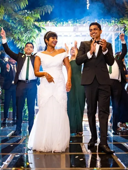The couple makes a grand entrance to their reception, surrounded by friends, sparklers, and applause.