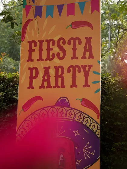 A close-up of a 'Fiesta Party' banner, with its fun typography and chili pepper motifs.