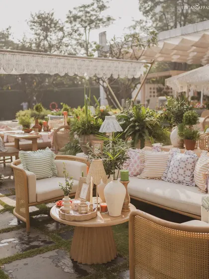 A comfortable lounge area with cane furniture and an abundance of printed cushions, creating a cozy and stylish corner.