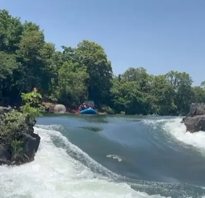 The view from upstream as a raft prepares to enter a set of rapids on the Kali River, surrounded by the area's natural rock formations.