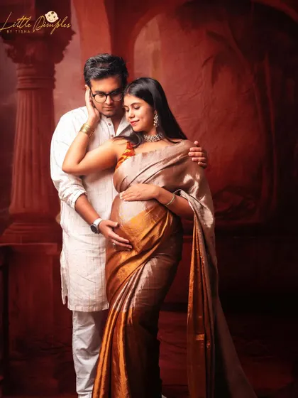An intimate moment between a couple during their traditional fine art maternity session. The warm red background adds to the romantic feel of the portrait.