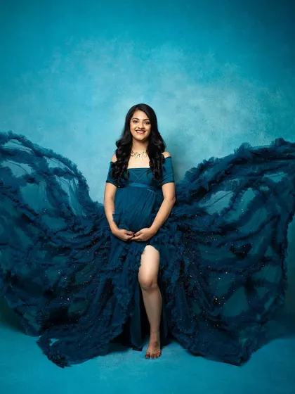 A powerful and beautiful maternity photo. The flowing gown and confident pose are complemented by makeup that is both strong and feminine.