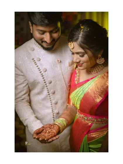 A close-up of the couple during their engagement, showing the bride's beautiful henna and her elegant saree.