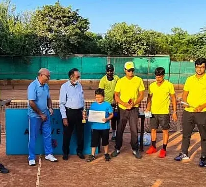A young player from our U-10 category proudly holding his certificate. These moments are crucial for motivating the next generation of tennis champions.