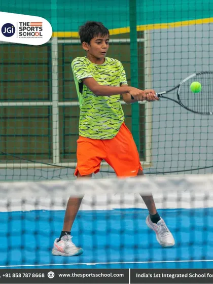 A player mid-swing, connecting with the ball for a powerful groundstroke during a training rally.