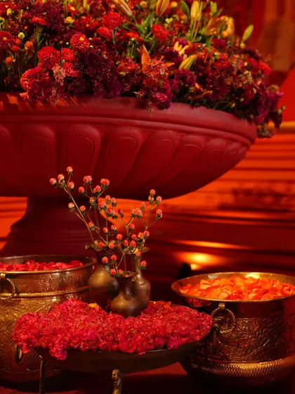 Close-up of the traditional decor elements, including brass bowls filled with fresh flowers and sindoor.