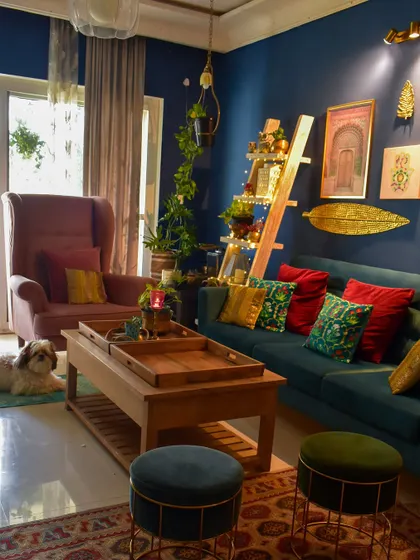 My living room, ready for festivities. You can see my little furry boy enjoying the cozy setup with the teal sofa, colorful cushions, and a decorative ladder.