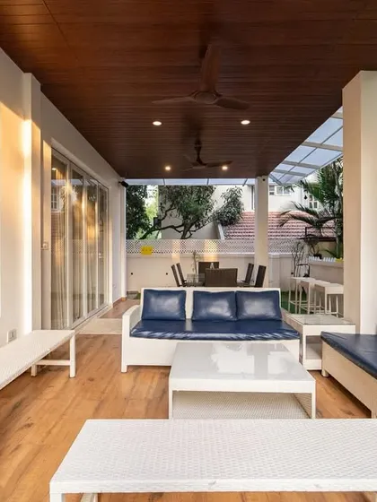 A closer look at the coastal-inspired terrace setup, where the combination of white wicker, navy blue, and natural wood creates a breezy, beachy feel.