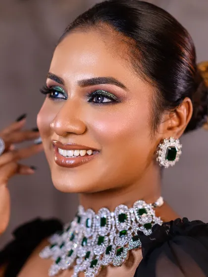 A smiling portrait that still highlights the quality of the makeup. This shot shows a glamorous evening look with emerald green eyeshadow and a perfectly matching diamond necklace.