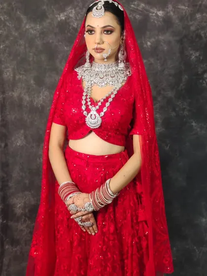 A full view of the bride in the red lehenga with the heavy, multi-layered American Diamond set. A showstopper look for a grand reception.