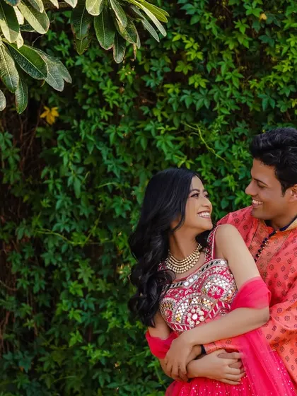 A sweet, candid moment between the couple against a lush green backdrop. The way they look at each other tells a story of love and happiness.