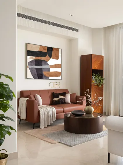 This cozy nook within the Casa Zen living area features a comfortable tan leather sofa and abstract art. It demonstrates how I create distinct zones within a larger space, each with its own mood, while maintaining a cohesive design narrative through color and material choices.