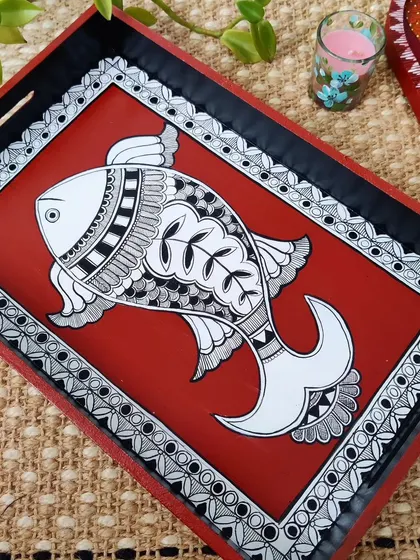 A closer look at the Madhubani fish tray. The intricate black and white line work on the vibrant red background is a hallmark of this beautiful folk art style.