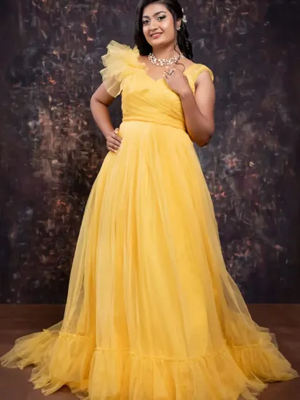 A full-length shot of the client in the yellow tulle gown, showing its elegant trail.