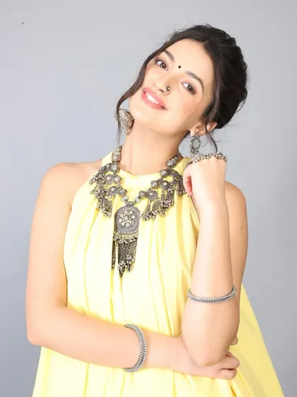 This pose highlights the statement silver jewelry. The makeup was intentionally kept clean with a soft lip color to ensure the accessories and the model's expression were the main focus.