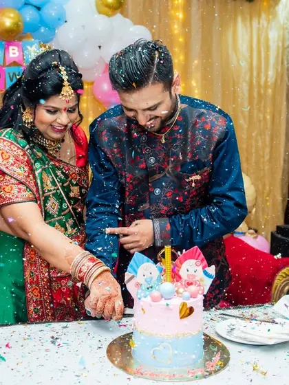 The excitement of the gender reveal cake cutting. Surrounded by confetti and the smiles of their family, this action shot captures the peak moment of the baby shower celebration.