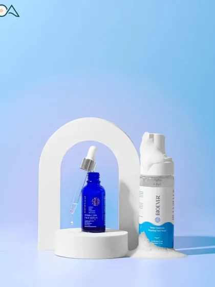 A refreshing product shot for a face serum and cleanser, using a cool blue background and props that suggest water and purity.